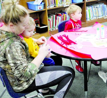 Haylee Young, Carson Campbell and Luke Ketterman make Christmas crafts during the Parents as Teachers event at Dear Elementary. The program helps children from prenatal to five years old to guide them before schooling.
