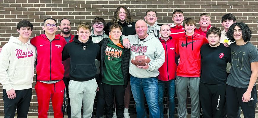 MIKE KARL IS HONORED to receive a football signed by the Richmond High football team seniors. Shown are, back row, from left, coach Nick Persell, Larry Penniston, Jack Gouge, Hunter Bowman, Thomas Murphy, Eli Steele and Joe Burch; front row, Joshua Pyle, Donivin Williams, Aidan Ivison, Bailon Stockton, Karl, Trevin Quick, Dayne Loftin, TJ Rush and Donte Pringle. SOPHIA BALES | Staff