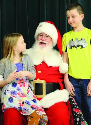 EDEN REED (from left), Santa and Gabriel Reed discuss Christmas presents.