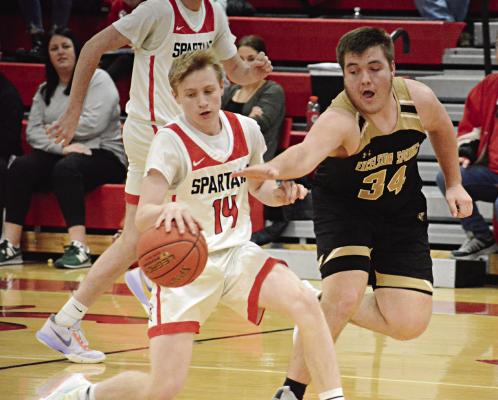 NOLAN QUICK, a first-year high schooler, shields the ball from Excelsior Springs senior Ryan Gluhm during the fourth quarter of the Spartans’ 71-43 victory Tuesday night at Richmond High School. SHAWN RONEY | Staff