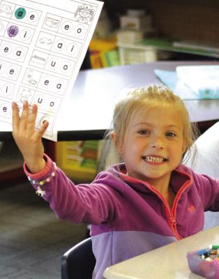 Alythia Miller holds up her worksheet during Dear Elementary summer school .