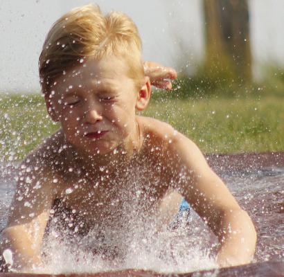 Owen Johnson gets a great splash as he slides down the slip-n-slide. See more photos on page 7. SOPHIA BALES | Staff