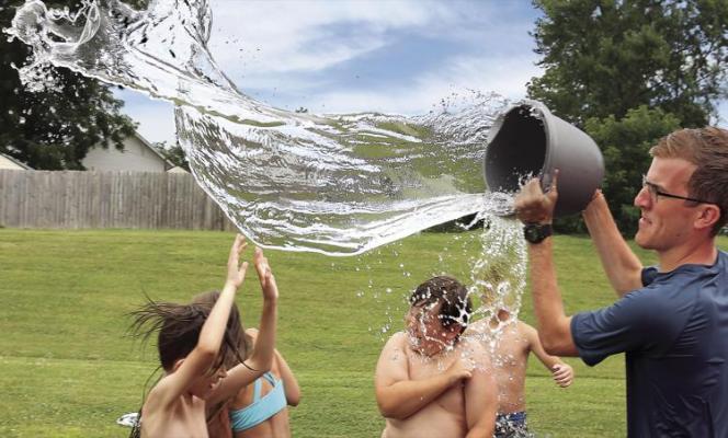 AT RICHMOND United Christian Presbyterian Church Camp, a welcome bucket of water on a hot day douses camp student Christian Branch. Camp counselor Brian Walker delivers the water.