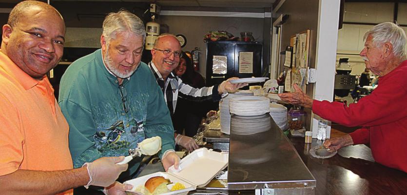 AT THE 2019 Thanksgiving Dinner, from left, Pastors Rance Williams, Eddie Birdsong and Phillip Powers work together to prepare a plate for Lloyd Walker. J.C. VENTIMIGLIA | Staff
