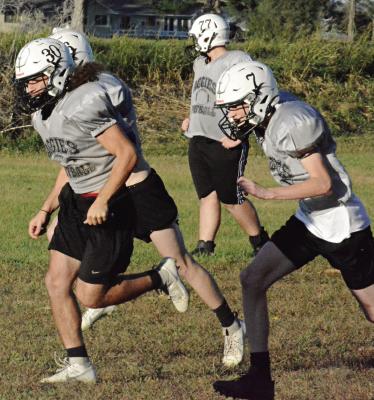 DENVER DOUGLAS (No. 30) and Kaden McGinnis (No. 7) are among the NHC skill position players running wind sprints Monday at Hardin-Central. SHAWN RONEY | Staff