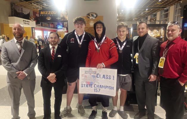 RICHMOND JUNIOR Elijah Sanders displays his championshp poster after winning the 157-pound title at the Class 1 state boys wrestling tournament, held Feb. 22-23 at Mizzou Arena in Columbia. Also pictured are, from left, Nic Joint; Kayhan Karimi; senior Larry Penniston, sixth place, 285; senior Aidan Ivison, fifth place, 190; Cody Hogan, Richmond coach; and Aaron Misenhelter. JORDAN HEBER | Submitted