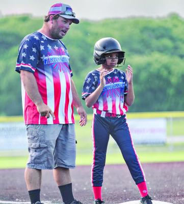 RAY COUNTY FIRECRACKERS assistant coach Norman Clevenger III gives Ava Minor some instruction while she stands on third base. TRICIA SLADE | Submitted