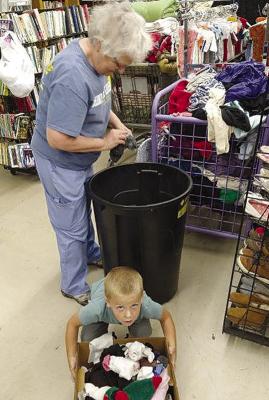Micah Trout helps Patty Thompson (standing) sort socks. DAVE DONALDSON | Staff