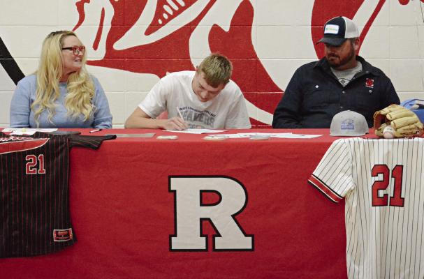 FLANKED BY his mother, Paula Patrick (left); and father, John Mitchell, Richmond senior Hunter Mitchell signs his letter of intent to play baseball at Pratt (Kan.) Community College Nov. 17 in the Richmond High gym. SHAWN RONEY | Staff