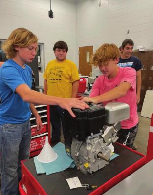 IN AN EARLY stage of learning for the class, Xander Carpenter and Wyatt Rice work on a small engine.