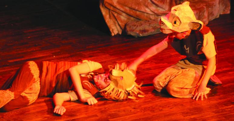 SIMEON DURHAM (left) plays Mufasa lying on the floor and Elijah Durham plays young Simba mourning the loss of his father.