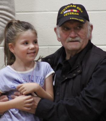 MILA NICOLL (left) sits with her grandfather, Clyde Hines, after the Dear Elementary Veterans Assembly last week. SOPHIA BALES | Staff
