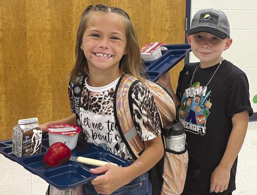 GRACIE HICKS (left) and William Woolfolk stand in the breakfast line on their first day back to Sunrise Elementary. SOPHIA BALES | Staff