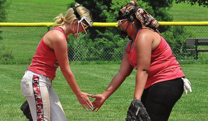SENIORS KAYDEN McCARTER, left, and Mykayla Thaxon exchange a low-five during Richmond’s softball camp. SHAWN RONEY | Staff
