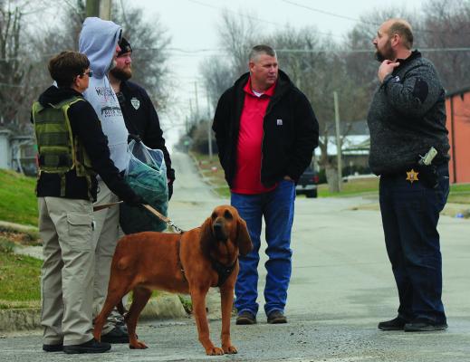 WESTERN MISSOURI CORRECTIONAL Center K9 Unit division personnel are in the area with a bloodhound, Molly, holding a bag of Justin Robinson’s clothing. Presiding Commissioner Billy Gaines and Ray County Sheriff Scott Childers discuss the next steps in finding Robinson, who escaped from the Ray County Jail Monday night. SOPHIA BALES | Staff