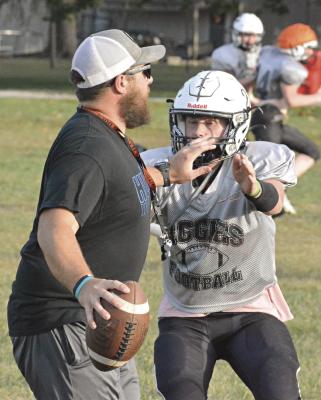 THIRD-YEAR COACH Andrew Watson, sporting his shades and ballcap while fending off pass rusher Zach Deitch during a September practice, has his first victory over Missouri Highway 10 rival Orrick in varsity 8-man football. SHAWN RONEY | Staff