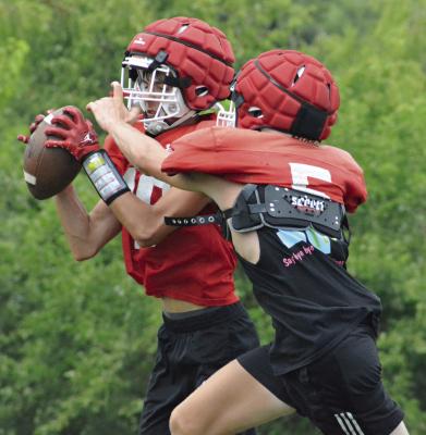 BAYLON CASTILLEJA uses his height to shield the ball from Bryer Farnan and make a two-handed catch while running through passing drills during Richmond’s team football camp session Monday at Richmond High School. SHAWN RONEY | Staff