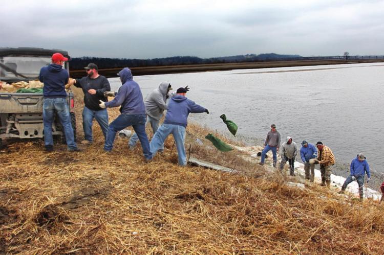 NEAR THE ROUTE J bridge, volunteers work in 2019 to prevent the Missouri River and Crooked River from destroying the levee. Flood water pounds the levee for days, but with volunteer help, the levee holds. J.C. VENTIMIGLIA | Staff