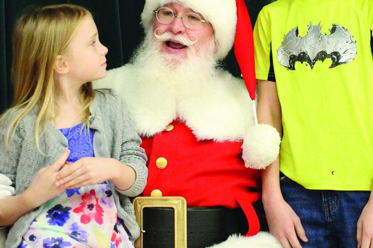EDEN REED (from left), Santa and Gabriel Reed discuss Christmas presents.