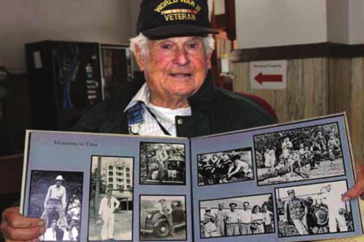 RAY COUNTY’S oldest World War II veteran, Ken Thomas, holds a scrapbook full of photos he collected during the war, when he worked to rework faulty torpedo firing pins in a Pearl Harbor machine shop. J.C. VENTIMIGLIA | Staff