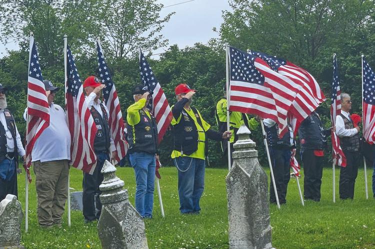 MILITARY VETERANS hold American flags and salute in honor of their fellow soldier Cpl. Charles Ryan Patten, who died in the Korean War. MIRANDA JAMISON | Staff