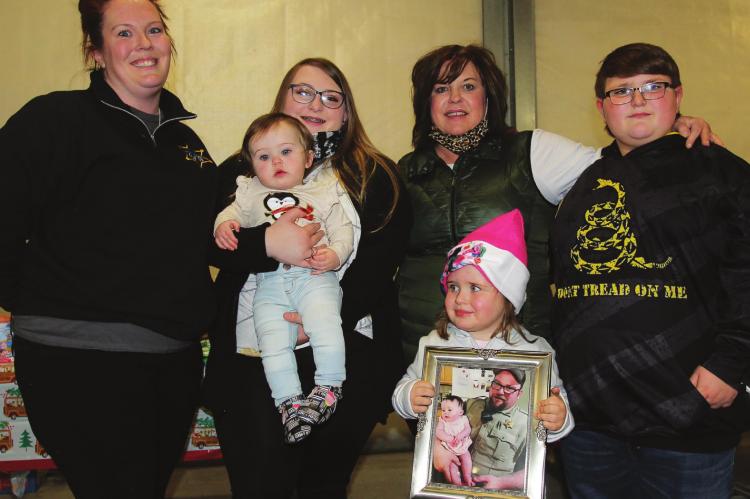 THE LATE Jeff Perkins – a sheriff’s sergeant who led the Shop With a Sheriff program – loses his life to natural causes in October. His wife, Melissa Perkins, steps up to continue the effort. From left are Melissa Perkins, Natalie and Journey Perkins, Mollie Perkins, Wendy Essig and Logan Perkins.