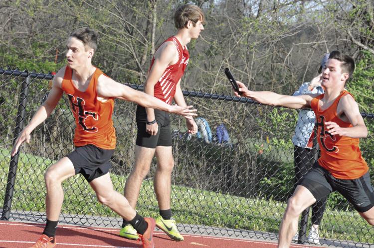 STRETCHING BACK with his left hand, Brody Fifer reaches to grab the baton from Hardin-Central teammate Kameron Pugh during the boys 800-meter relay race April 11 at the Bill Hamann Invitational at Lexington. SHAWN RONEY | Staff