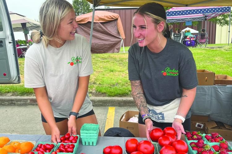 SOPHIA BALES | Staff Wellington residents Alison Dehn (left) and Sydney Rukavina converse as they prepare to sell fruit and vegetables at the Summer Bash and Market. See story on page 5.