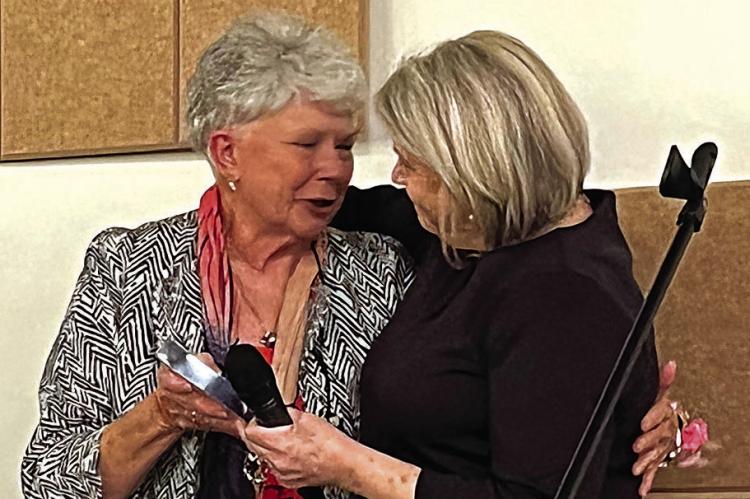 PEGGY HACKETT, left, and Stephanie Landwehr hug while Hackett accepts the Lifetime Award Oct. 20 from the chamber for her business, JP’s Total Image. SOPHIA BALES | Staff