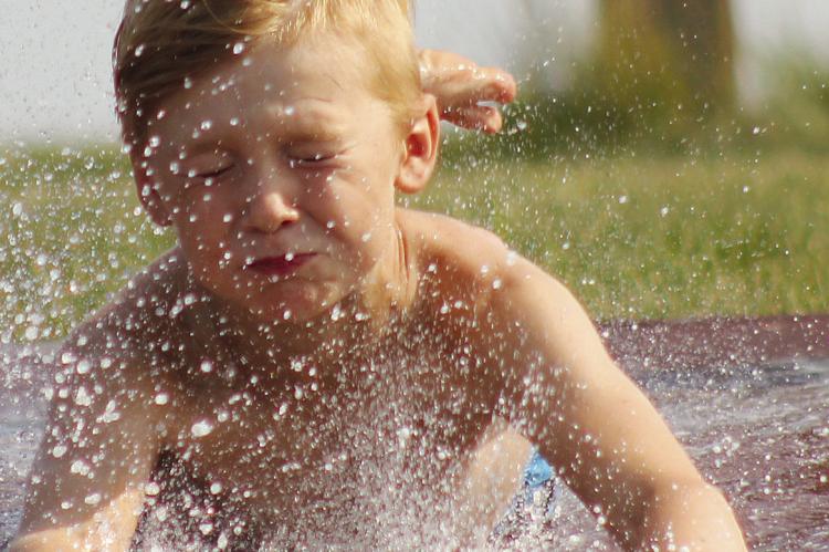 Owen Johnson gets a great splash as he slides down the slip-n-slide. See more photos on page 7. SOPHIA BALES | Staff