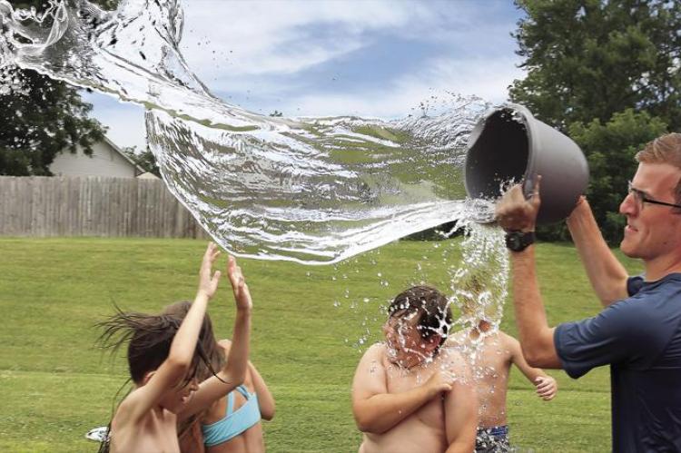 AT RICHMOND United Christian Presbyterian Church Camp, a welcome bucket of water on a hot day douses camp student Christian Branch. Camp counselor Brian Walker delivers the water.