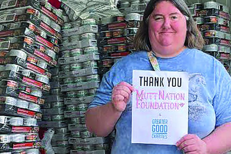 Bark Bargain Thrift Shop Manager Jenifer Dickson accepts the “Muttnations and the Goods” food donations for the pantry. JENIFER DICKSON | Submitted