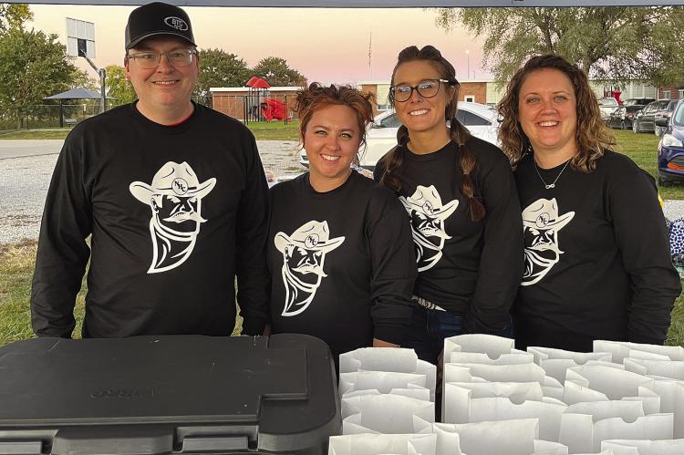 BTC BANK staffers and participants Jason Frazer (from left), Megan Armstrong, Jenna Miller and Tesha Buhrmeister serve $5 meals at the Hardin-Central game last week. SOPHIA BALES | Staff