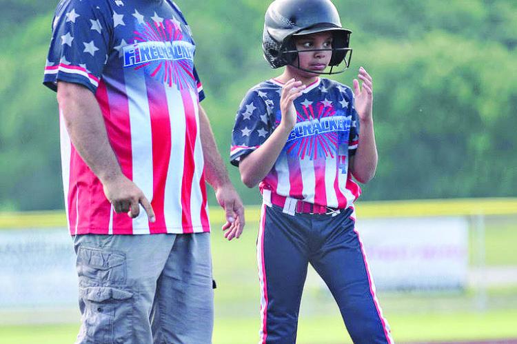 RAY COUNTY FIRECRACKERS assistant coach Norman Clevenger III gives Ava Minor some instruction while she stands on third base. TRICIA SLADE | Submitted