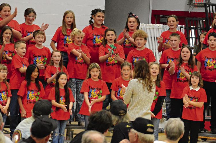 MEMBERS OF the Sunrise Singers, a vocal ensemble based at Sunrise Elementary School, work in some hand gestures as they perform for area veterans and their fellow Richmond students in the high school gym. SHAWN RONEY | Staff