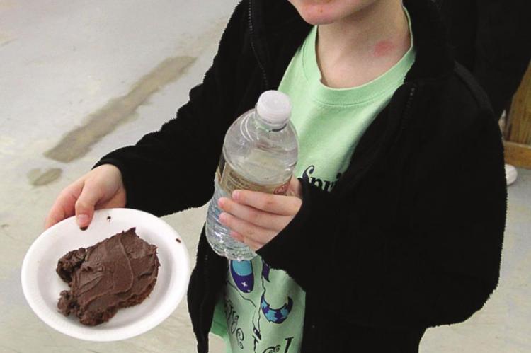 KINLEY SUHA, 7, takes chocolate cake.