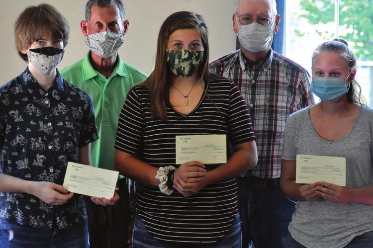 WEARING COVID-19 masks, front, from left, are Genevieve Keighly, Kassie McGinnis and Ashley Stewart. They display their Ray County Fair Harold Strobel Citizen of Service awards. Behind them stand Frazer Letzig and Ray County Fair representative Dean Richards.