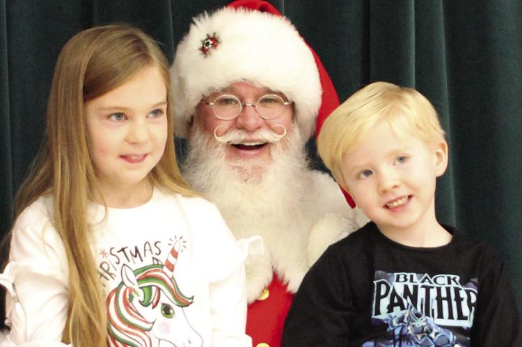 RYANN MADGET (from left), Santa and Reise Madget spend time with each other during breakfast with Santa event at Richmond Middle School. SOPHIA BALES | Staff