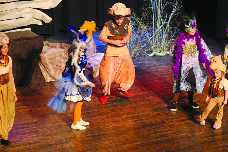 ELIJAH DURHAM (middle, from left) and QUINNLEY LAWSON play Simba and Zazu, respectively, as they dance around the stage during scene five, “I Just Can’t Wait to be King” song.