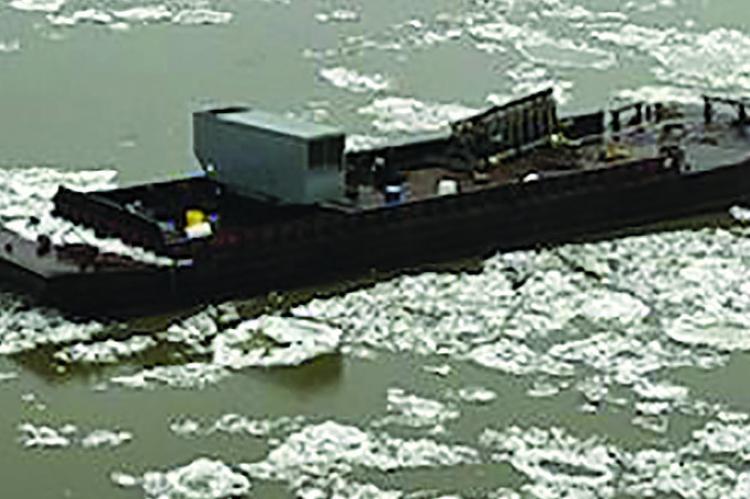 ONE OF TWO RUNAWAY barges float down Missouri River among ice flows. Submitted