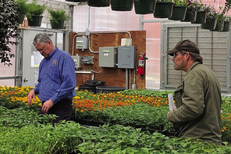 RHS TEACHER CHARLES FOREMAN (left) helps local resident Guy Kinnison pick some plants and vegetables during the RHS spring greenhouse sale. SOPHIA BALES | Staff