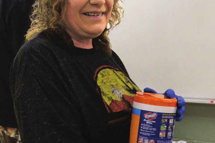 MAINTENANCE WORKER Rhonda Jones stands ready with approved disinfectant wipes.