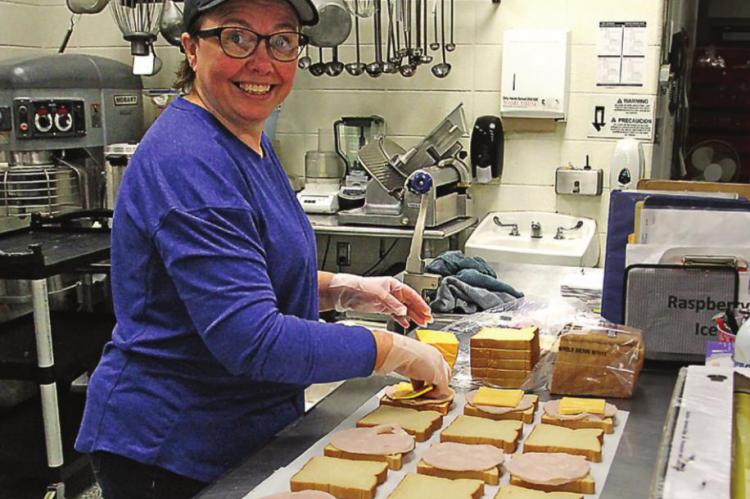 SANDWICHES are made with care and efficiency by cafeteria worker Debra Doss.